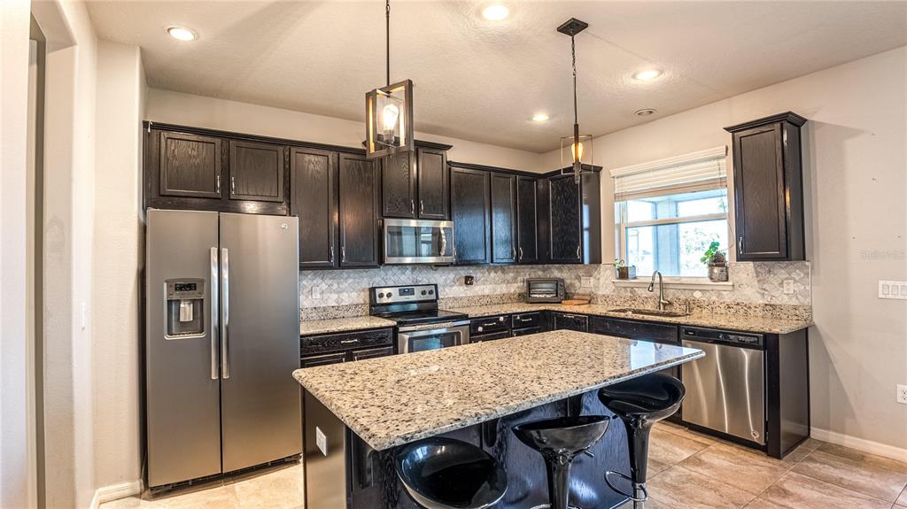 An aerial view of a two-story suburban house with a paved driveway and a lake — 2515 FONTAINE DRIVE, KISSIMMEE, FL
