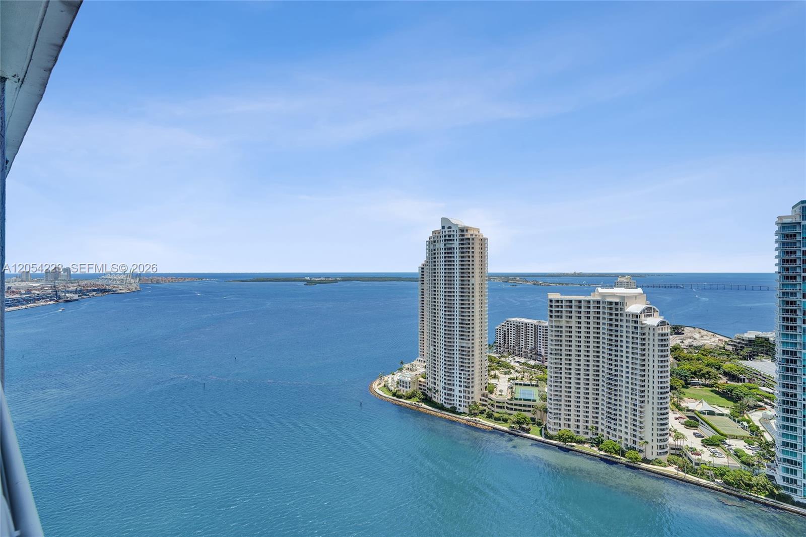 An elevated view overlooks a bay with high-rise residential buildings on a coastal point — 335 S Biscayne Blvd # 3807, Miami FL 33131, MIAMI, FL