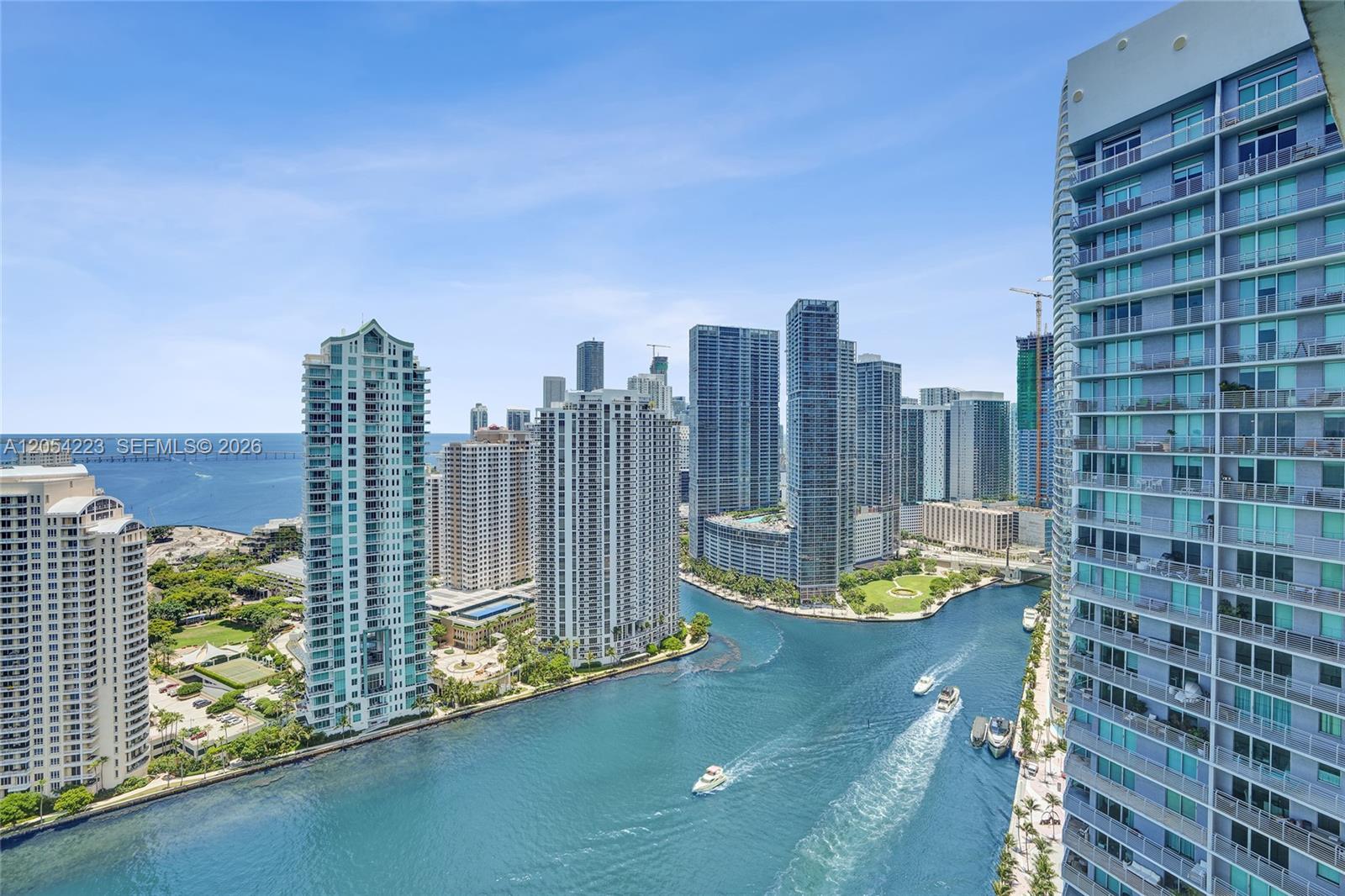 An elevated view of a city skyline featuring high-rise buildings along a river — 335 S Biscayne Blvd # 3807, Miami FL 33131, MIAMI, FL