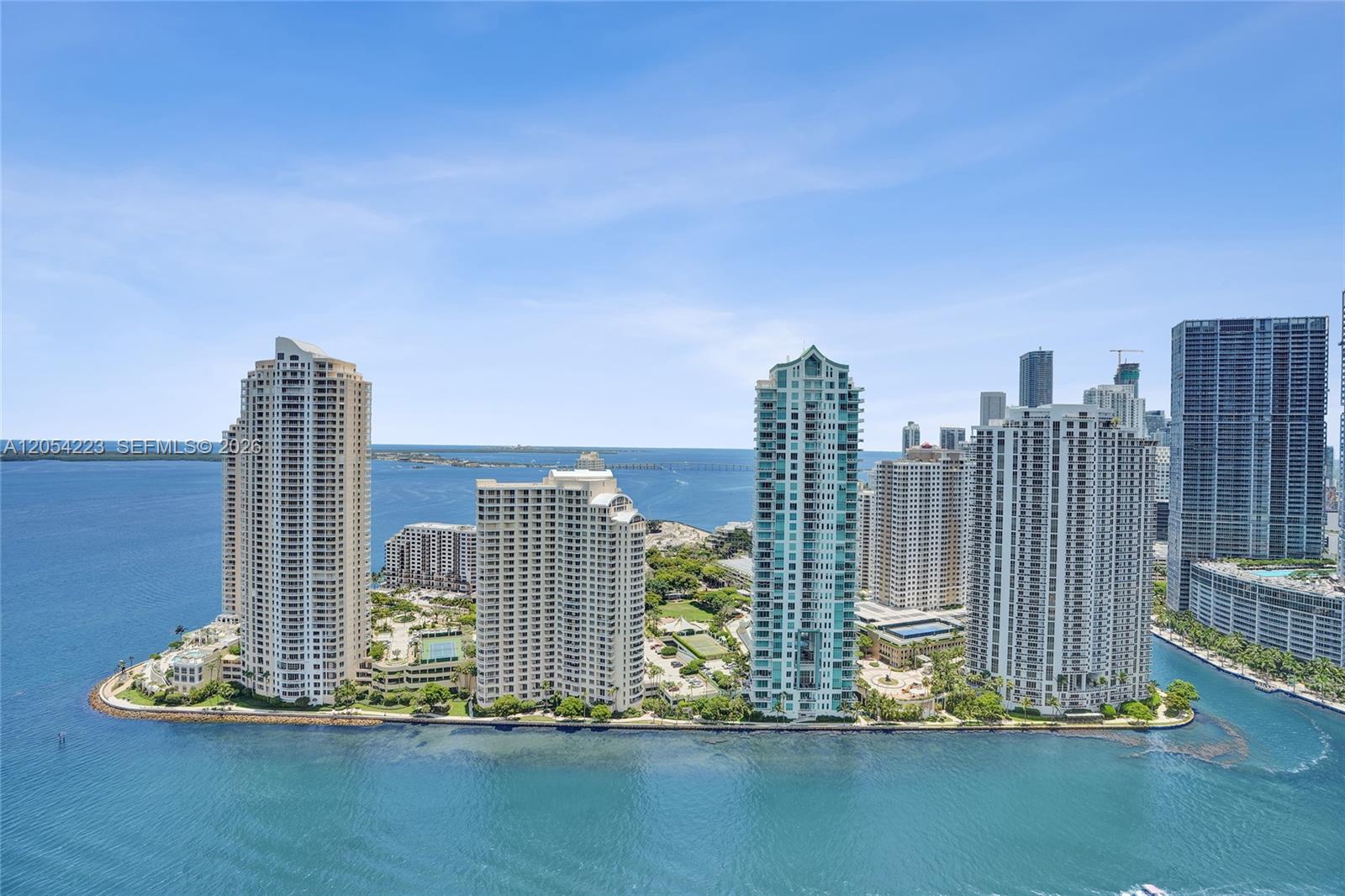 An aerial view shows several high-rise residential buildings situated on a waterfront peninsula — 335 S Biscayne Blvd # 3807, Miami FL 33131, MIAMI, FL