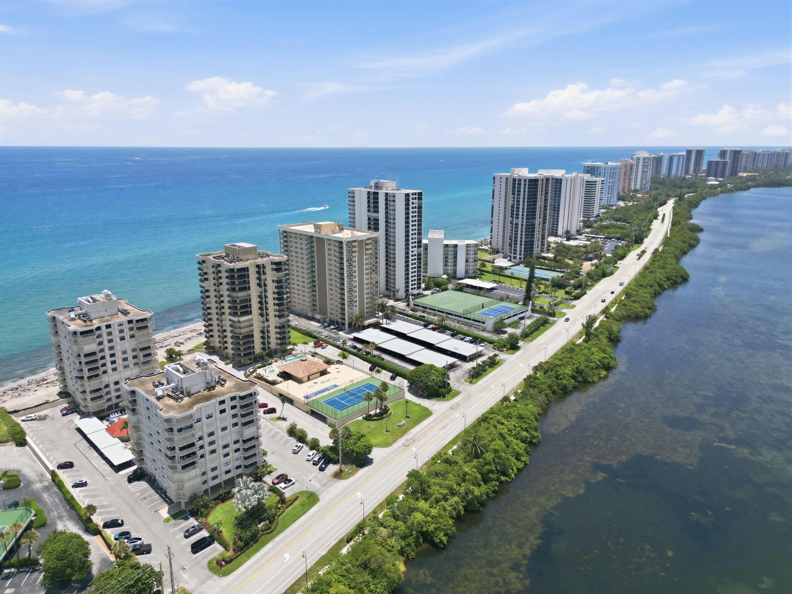 An aerial view shows high-rise residential buildings situated between the ocean and a coastal road — 5460 N Ocean Drive # 6a, Riviera Beach FL 33404, RIVIERA BEACH, FL