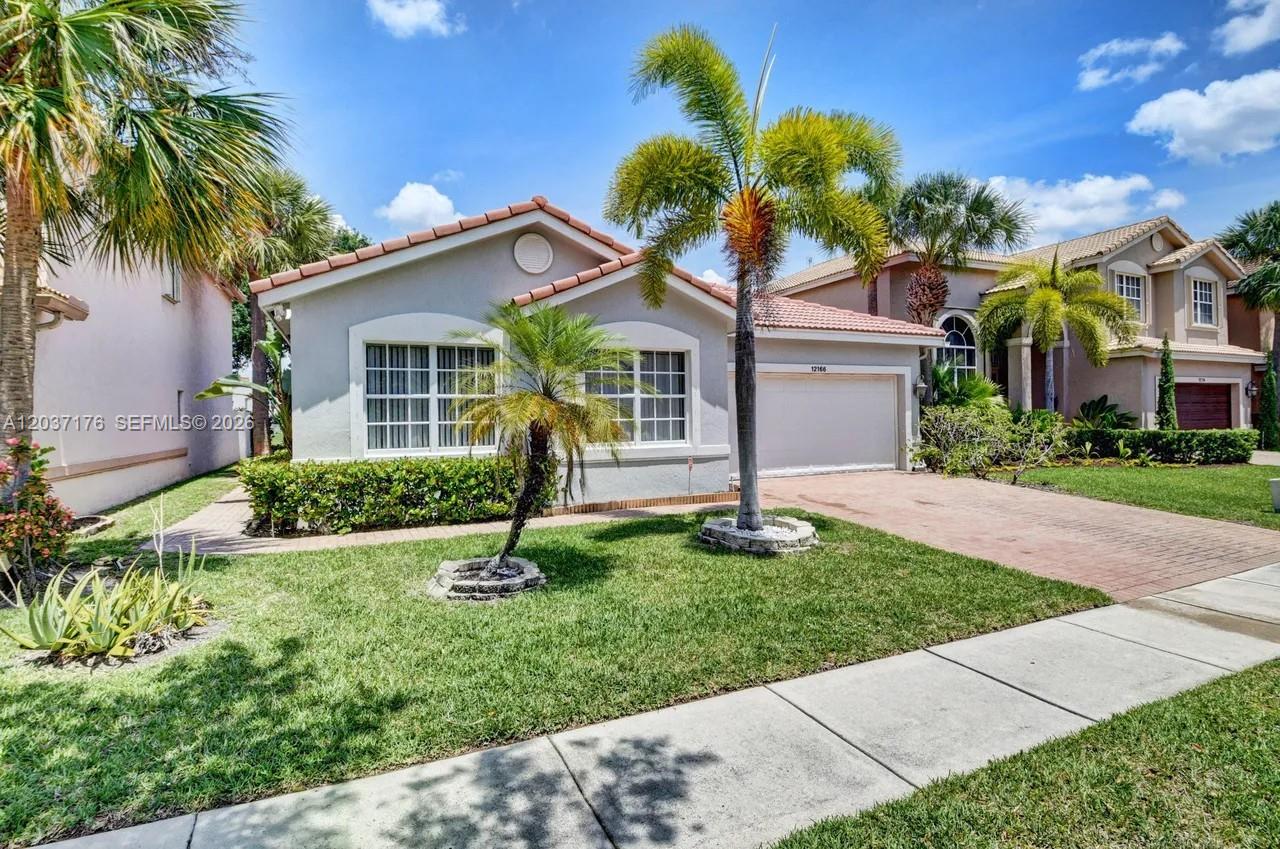 A single-story house with a tiled roof, a two-car garage, and palm trees in front — 12166 COLONY PRESERVE DR, Boynton Beach FL 33436, BOYNTON BEACH, FL