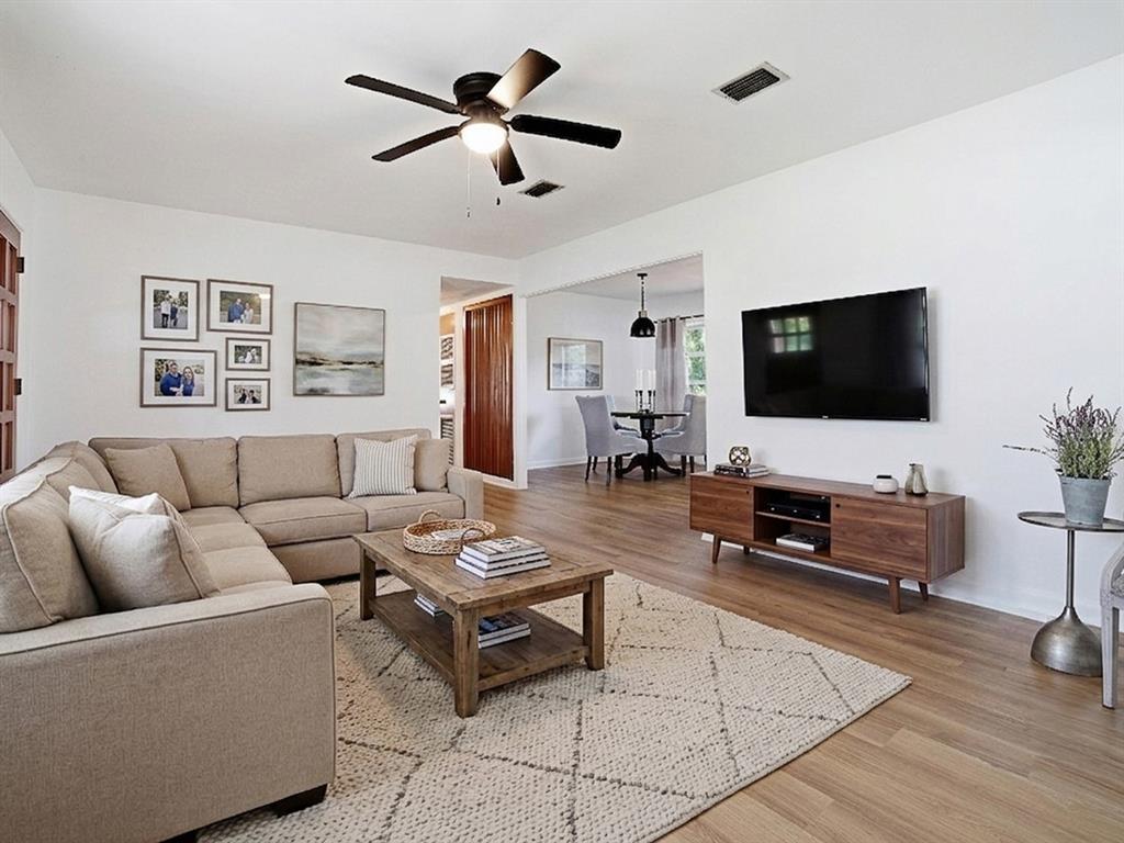 A living room features a beige sectional sofa, a wooden coffee table, and a wall-mounted television — 2269 SOUTHLAND ROAD, MOUNT DORA, FL