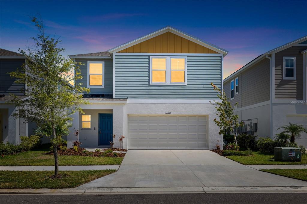 A two-story house with a blue door, white stucco base, and light blue horizontal siding — 14886 SUMMER BRANCH DRIVE, LITHIA, FL