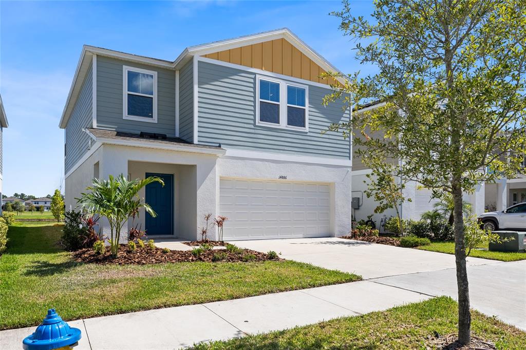 A two-story suburban house with blue siding, a white stucco garage, and a front lawn — 14886 SUMMER BRANCH DRIVE, LITHIA, FL