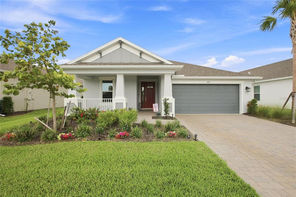 A single-story house with a white exterior, a front porch, and a gray garage — 1633 REMINGTON TRACE DRIVE, PORT CHARLOTTE, FL