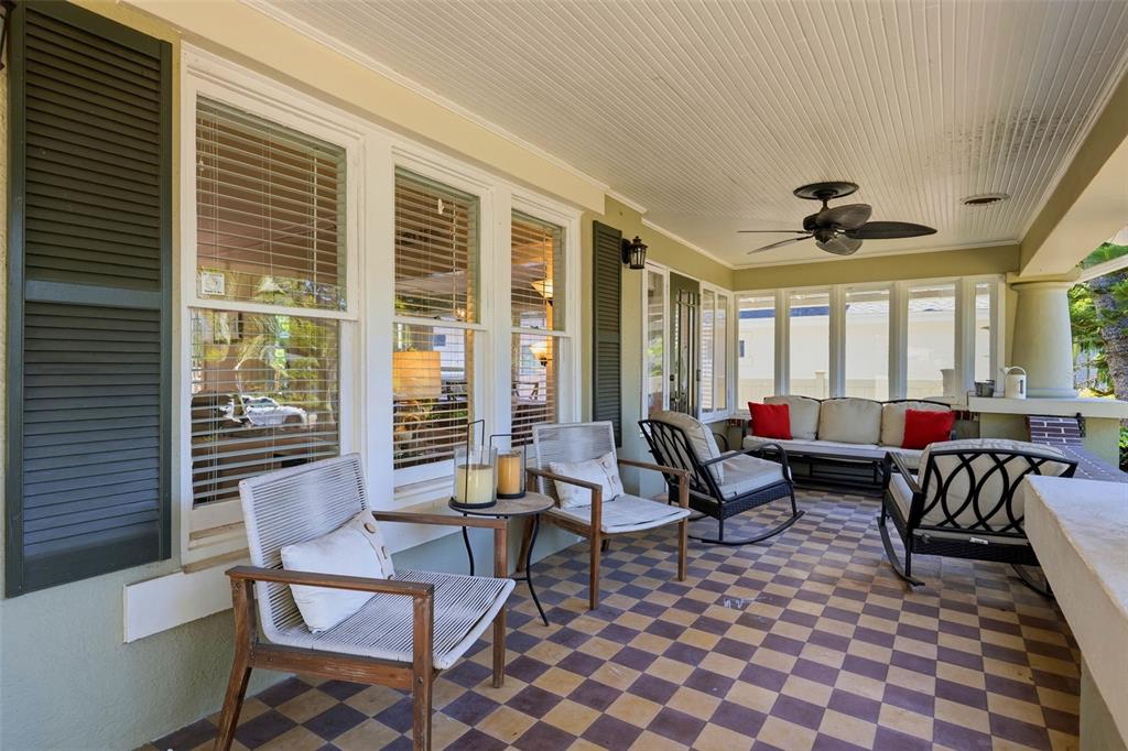 A covered porch features a checkered tile floor, outdoor seating, and a ceiling fan — 871 17TH AVENUE N, ST PETERSBURG, FL