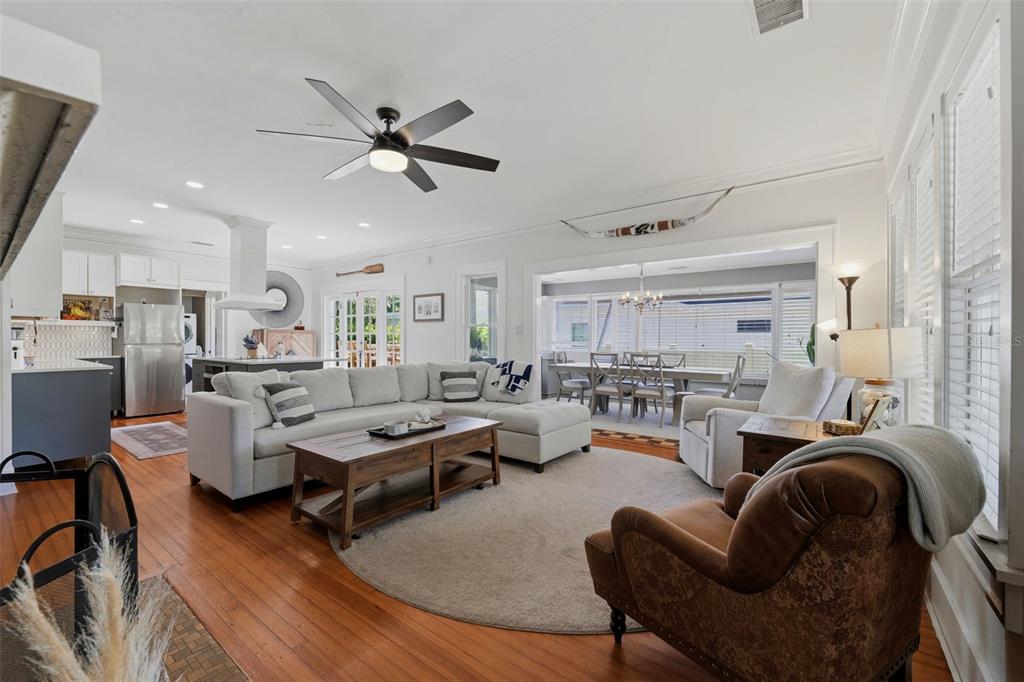 A living room with hardwood floors, a sectional sofa, and an open-concept kitchen — 871 17TH AVENUE N, ST PETERSBURG, FL
