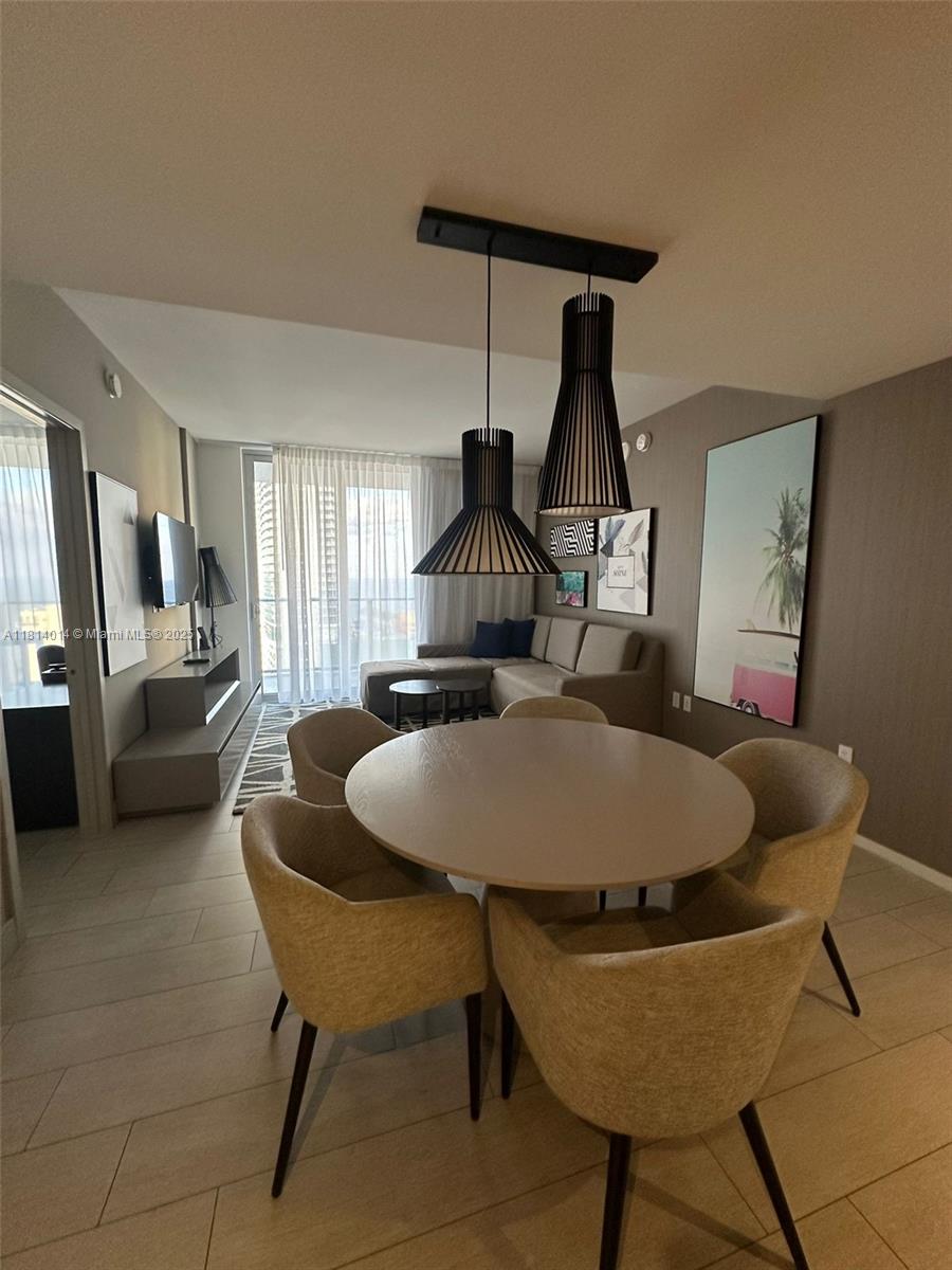 A dining area with a round table and chairs sits in front of a living room — 4010 S Ocean Dr # R1707, Hollywood FL 33019, HOLLYWOOD, FL