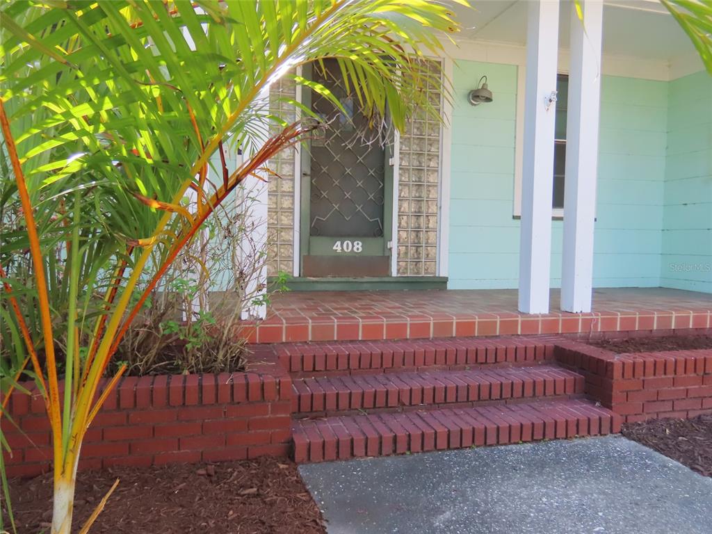 A front porch with red brick steps and a glass block entryway to a house — 408 27TH STREET W, BRADENTON, FL