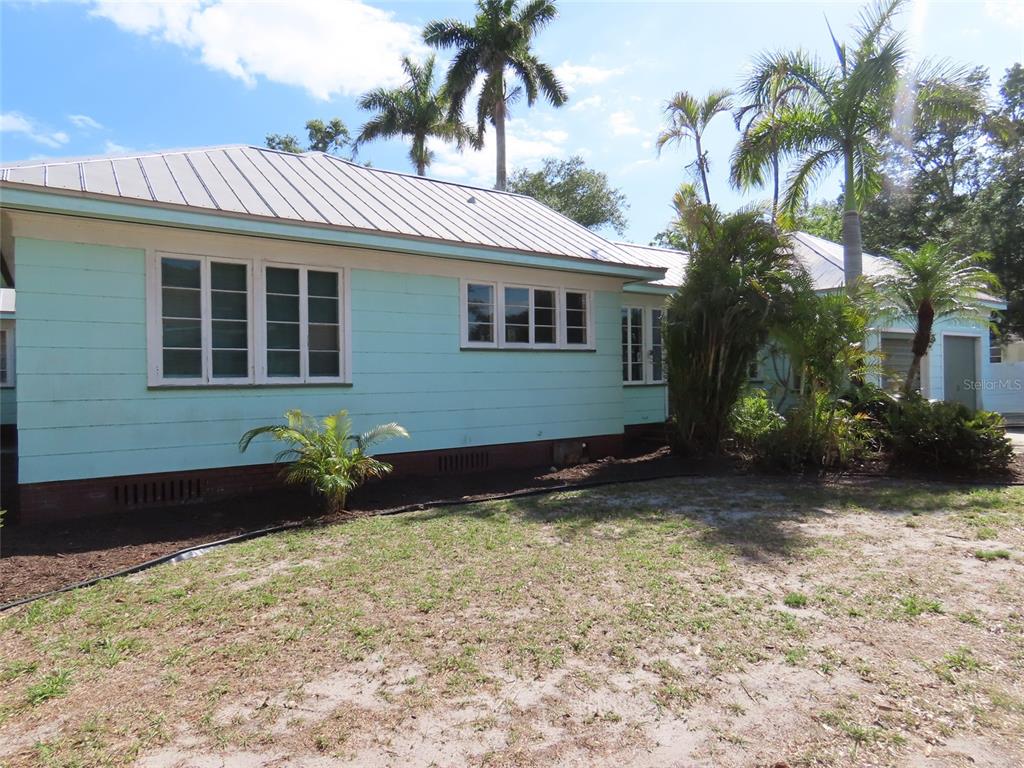 A light blue house with a metal roof and palm trees in the yard — 408 27TH STREET W, BRADENTON, FL