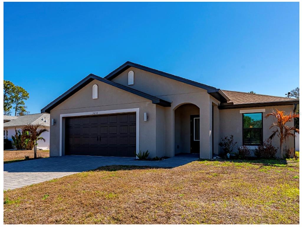 A single-story house with a brown garage door, tan stucco exterior, and a paved driveway — 3638 WENTWORTH STREET, NORTH PORT, FL