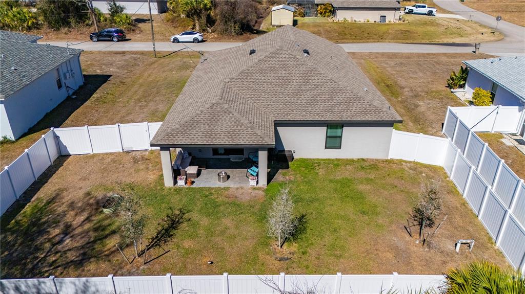 A kitchen features white cabinetry, granite countertops, a center island with stools, and wood flooring — 3638 WENTWORTH STREET, NORTH PORT, FL