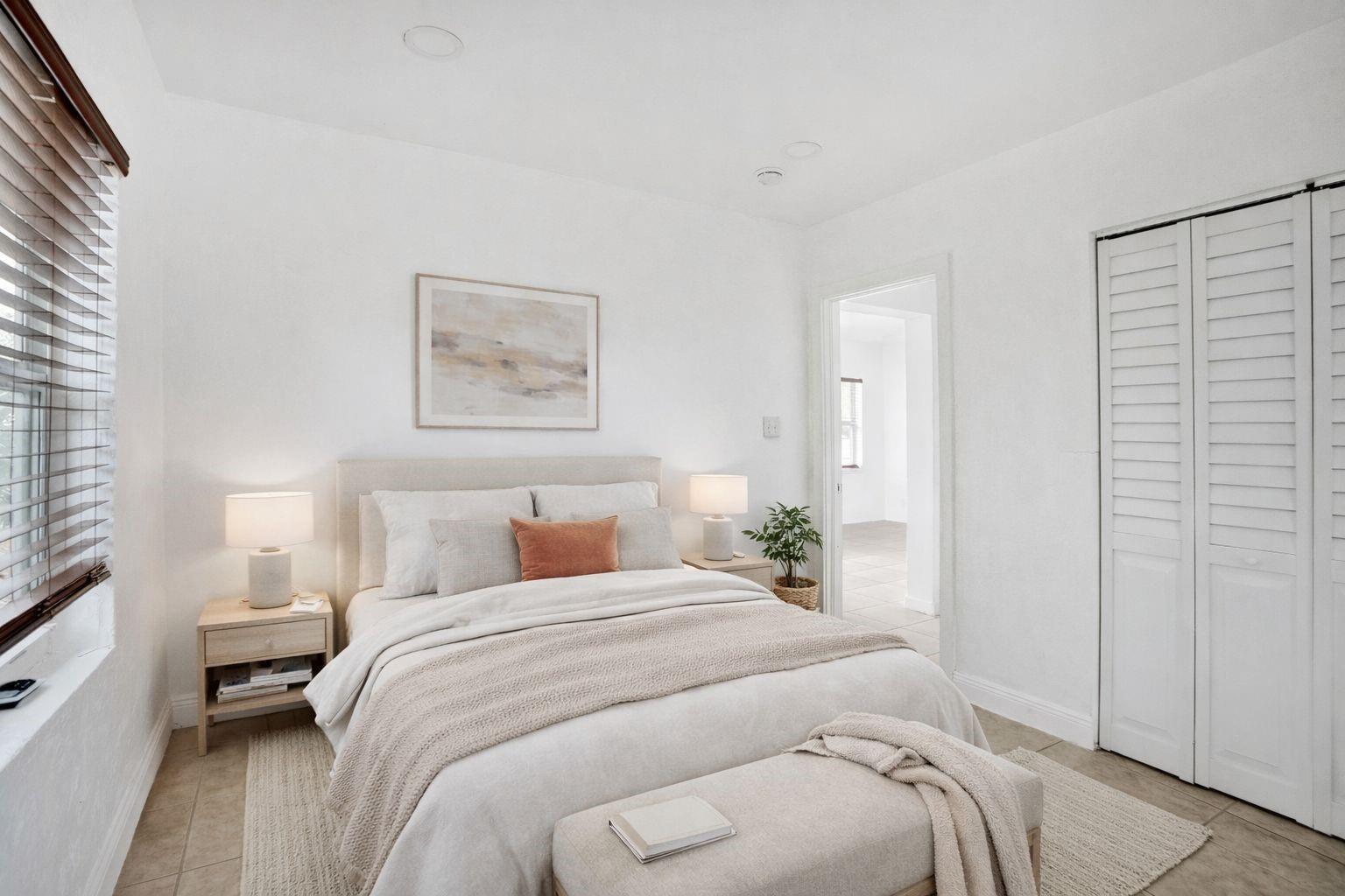 A neutral-toned bedroom features a queen bed, two nightstands with lamps, and a white closet — 306 NE 13th Avenue, Pompano Beach FL 33060, POMPANO BEACH, FL