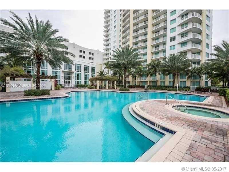 A swimming pool and hot tub are situated in front of a tall residential building — 1755 E Hallandale Beach Blvd # 1005E, Hallandale Beach FL 33009, HALLANDALE BEACH, FL