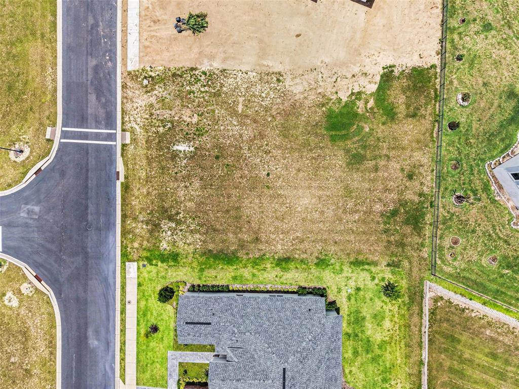 An aerial view shows a vacant residential lot situated next to a paved road — 212 SNOWY ORCHID WAY, LAKE ALFRED, FL