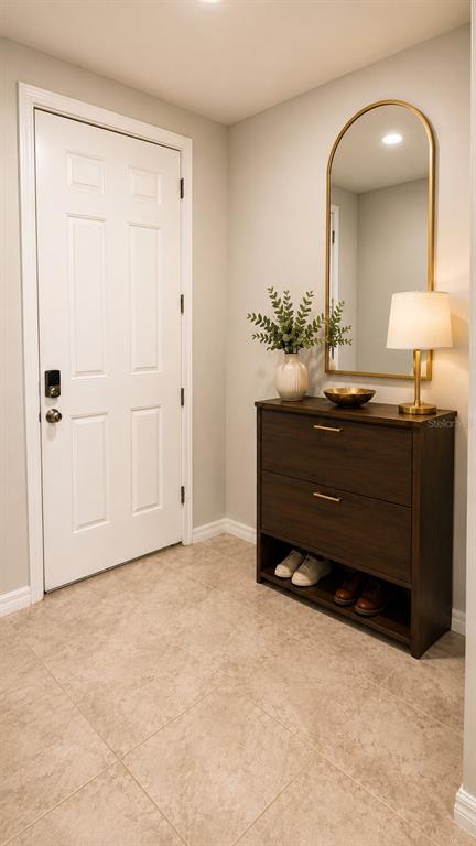An entryway features a white door, a dark wood shoe cabinet, and an arched wall mirror — 1562 GRAND RUE DRIVE, CASSELBERRY, FL