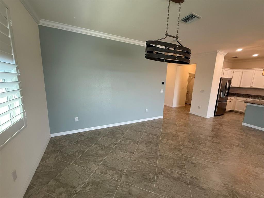 A dining area features a blue accent wall, tile flooring, and a rustic chandelier — 15153 SPANISH POINT DRIVE, PORT CHARLOTTE, FL