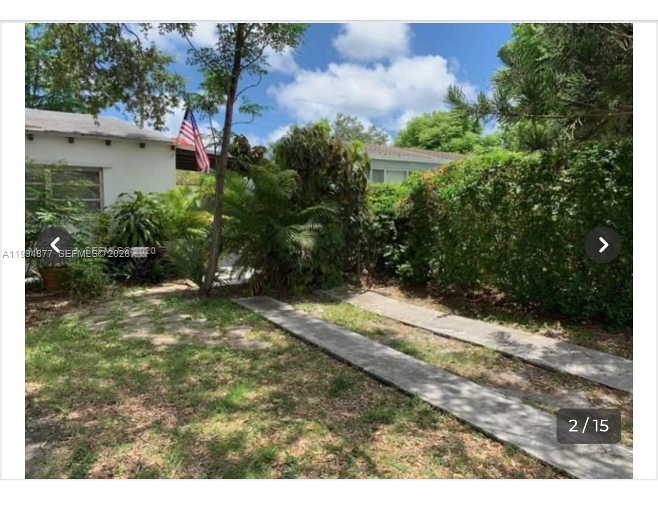 A grassy yard features a concrete driveway strip and dense green hedges beside a house — 4230 SW 11th St # 0, Miami FL 33134, MIAMI, FL
