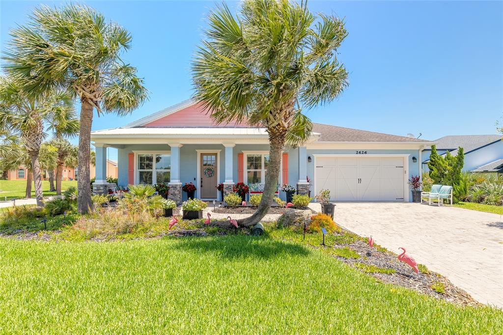 A single-story house with blue siding, a pink gable, and a palm tree-lined front yard — 2626 OSPREY CIRCLE N, FLAGLER BEACH, FL