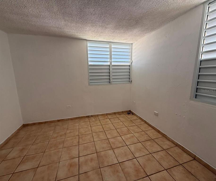 An empty room with white walls, tiled flooring, and two sets of louvered windows — Condominio Terrazul CONDOMINIO TERRAZUL UNIT 2/1, ARECIBO, PR