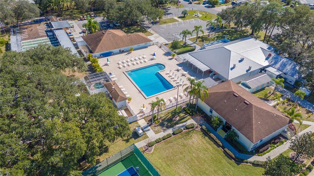 An aerial view shows a swimming pool, surrounding buildings, and a tennis court — 21 SILVERSIDES STREET, LAKE WALES, FL