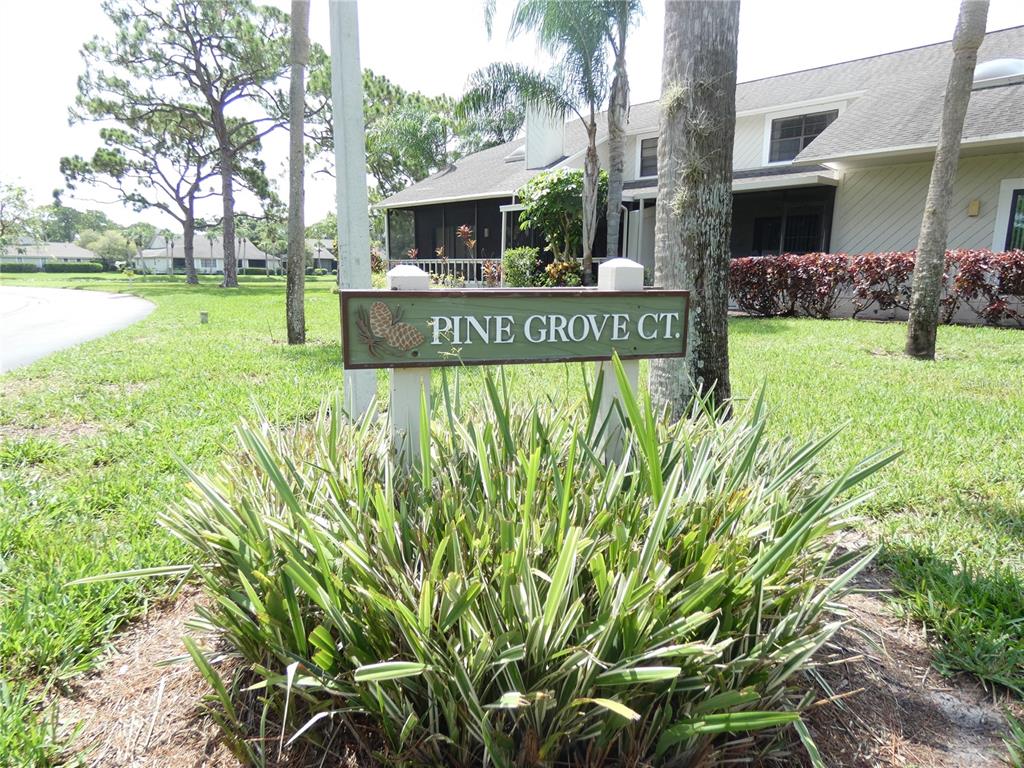 A street sign reading Pine Grove Ct. stands in front of a residential building — 7917 PINEGROVE COURT UNIT 1, SARASOTA, FL