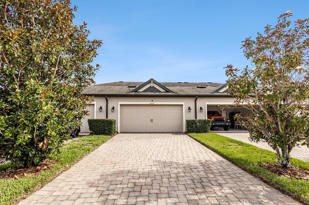 A paved driveway leads to a house with a two-car garage and a covered carport — 13027 BATTEN LANE, ODESSA, FL