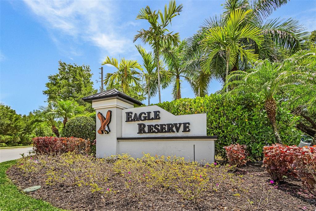 A white monument sign for Eagle Reserve stands in a landscaped garden with palm trees — 3990 SPOTTED EAGLE WAY, FORT MYERS, FL