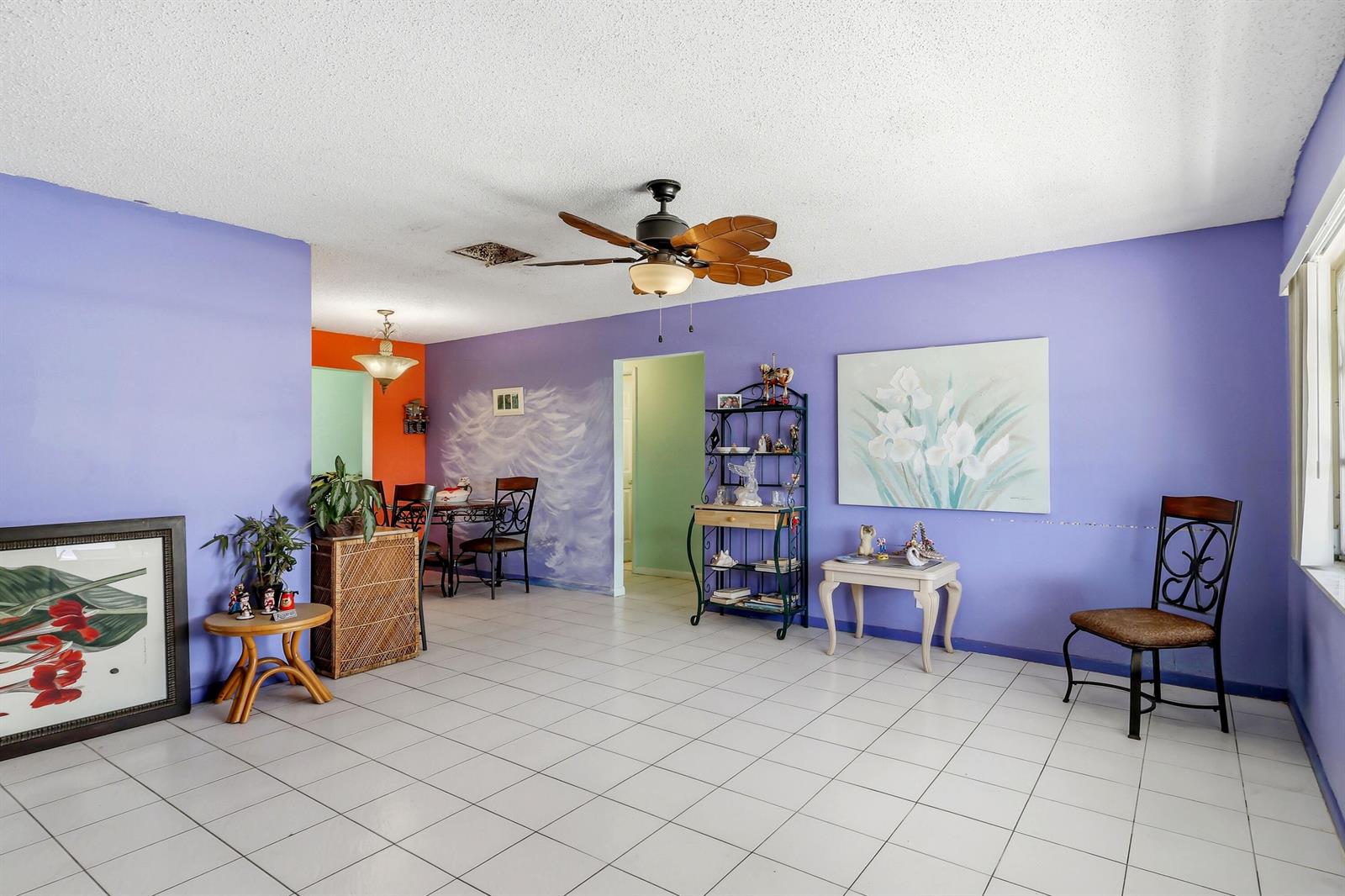 A living room with purple walls, white tile flooring, a ceiling fan, and dining area — 712 SW 18th Street, Boynton Beach FL 33426, BOYNTON BEACH, FL