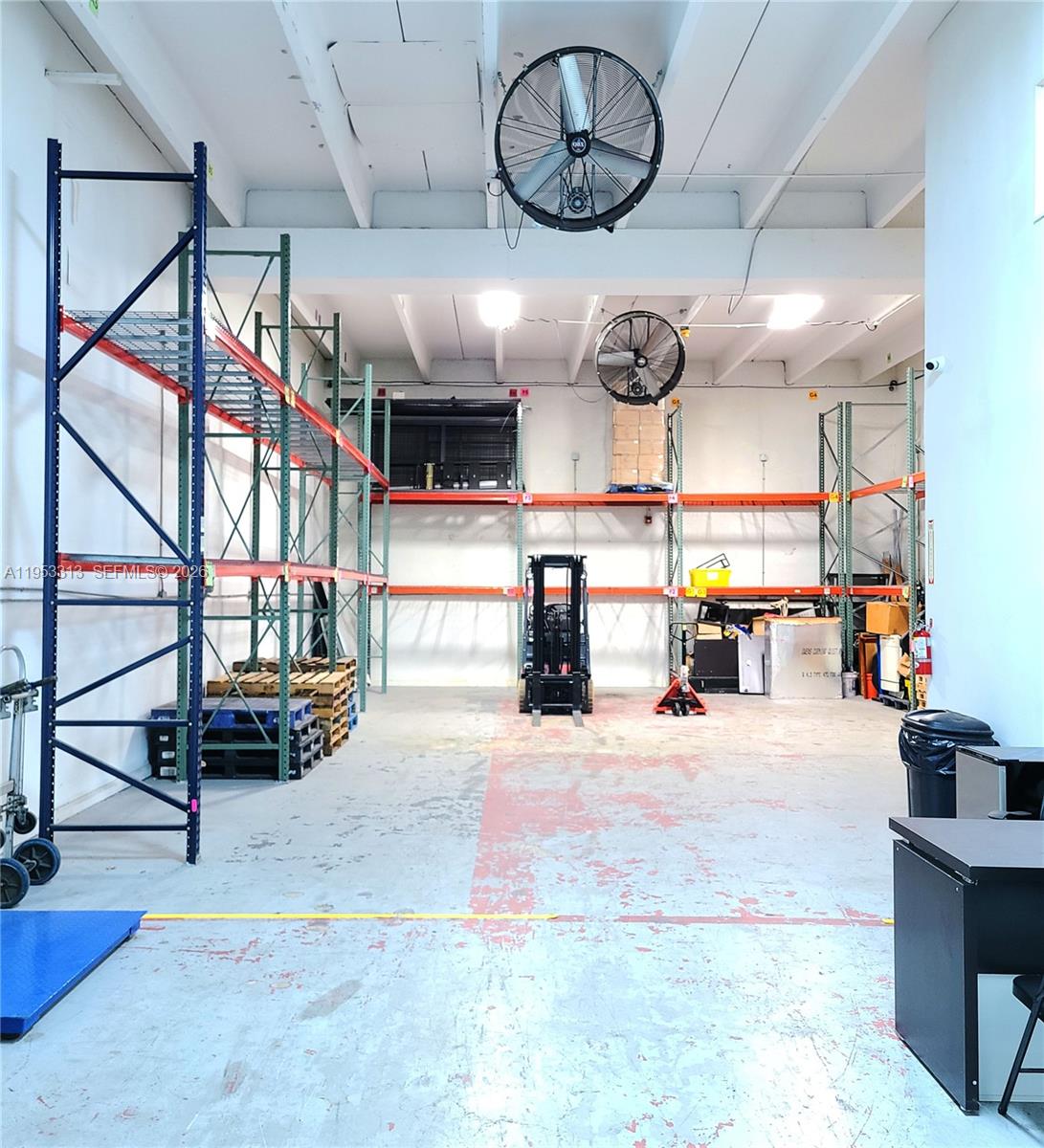 A warehouse space features industrial metal shelving, a forklift, and two large ceiling-mounted fans — 7344 NW 56th St # 7344, Miami FL 33166, MIAMI, FL