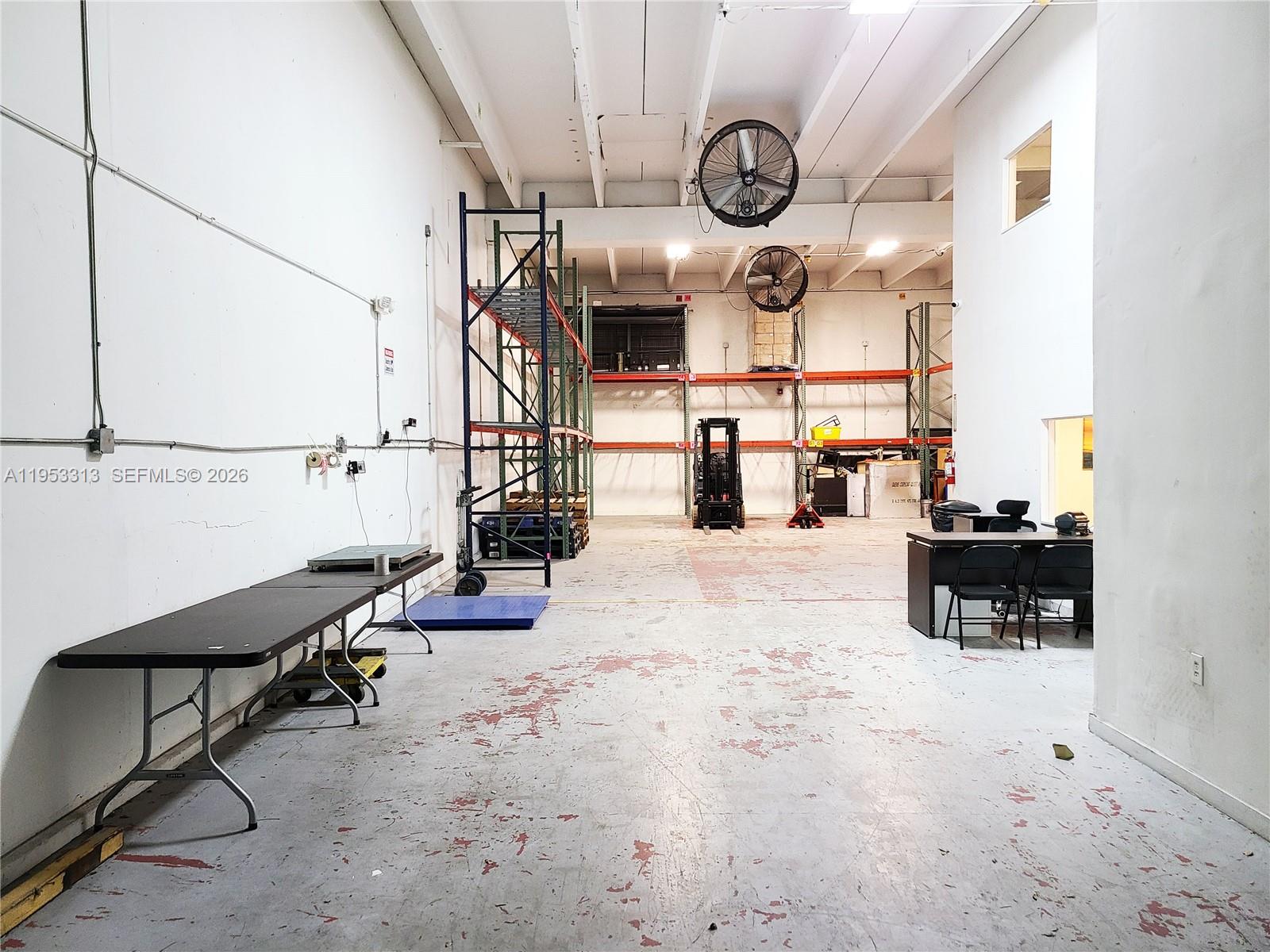 This warehouse space features a concrete floor, metal shelving units, a forklift, and office furniture — 7344 NW 56th St # 7344, Miami FL 33166, MIAMI, FL