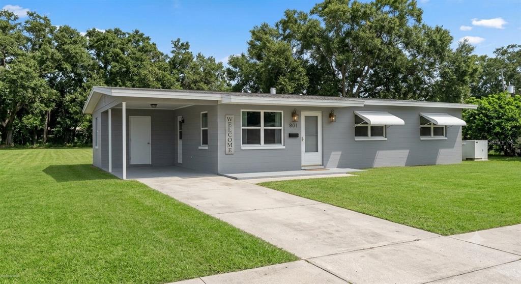 A single-story gray house with a carport and a large front lawn — 802 CRAWFORD STREET, DELTONA, FL