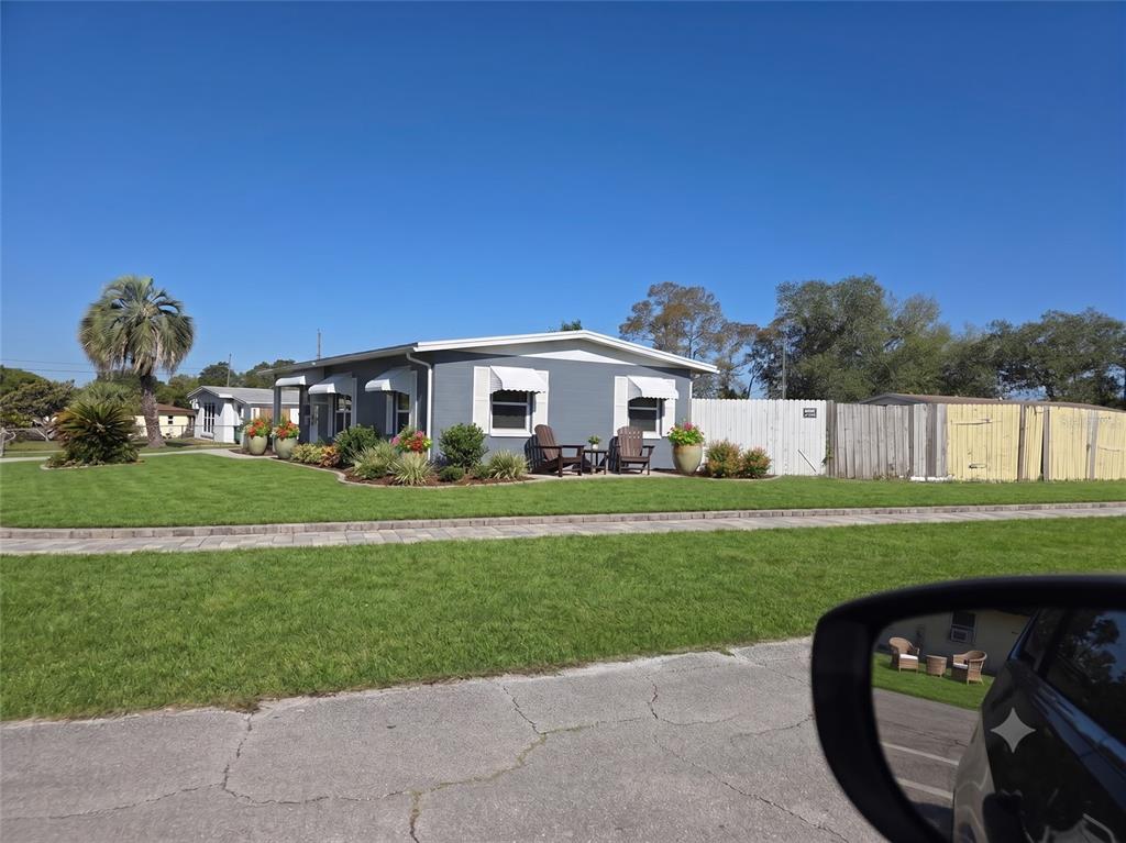 A sunroom features black and white tiled flooring, large windows, and a door leading outside — 802 CRAWFORD STREET, DELTONA, FL