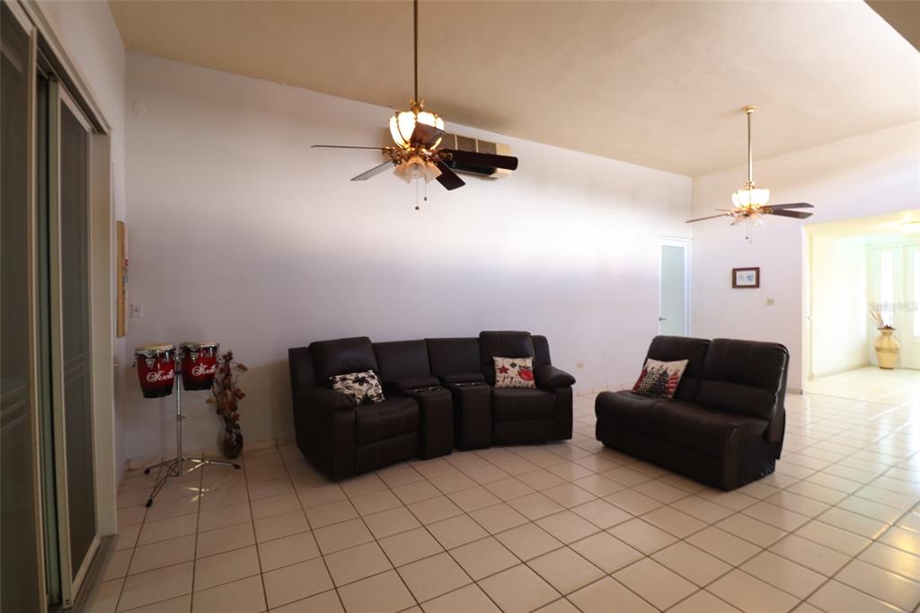 A living room with tile flooring, two dark brown sofas, and two ceiling fans — 62 San Luis St. ESTANCIAS DE GRAN VISTA DEV., GURABO, PR