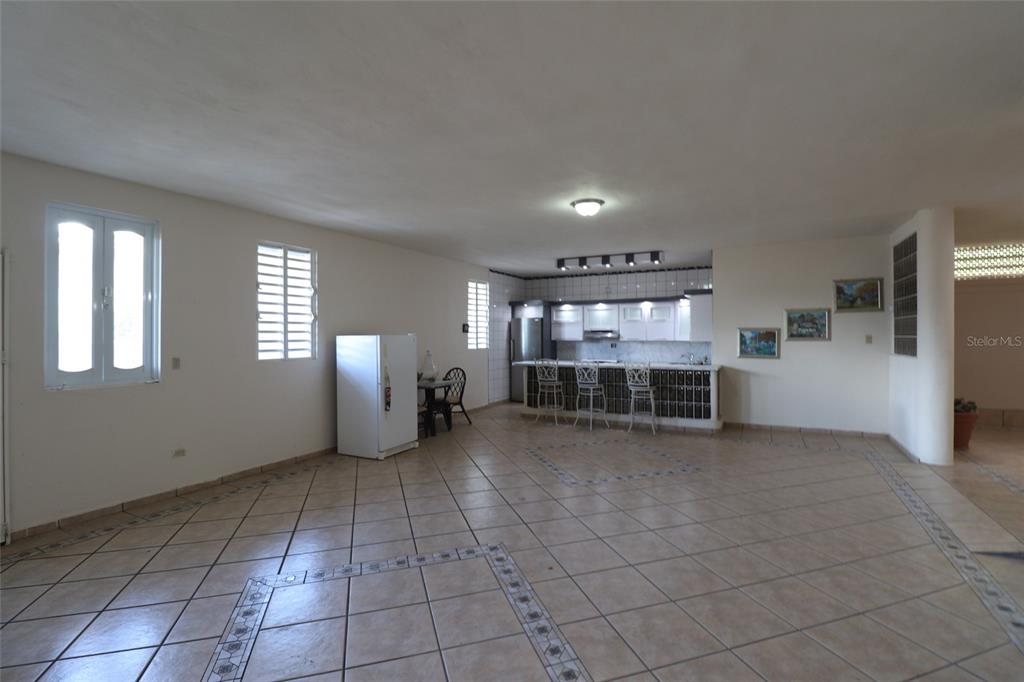 A spacious open-concept kitchen and living area features tiled floors and a breakfast bar — 62 San Luis St. ESTANCIAS DE GRAN VISTA DEV., GURABO, PR