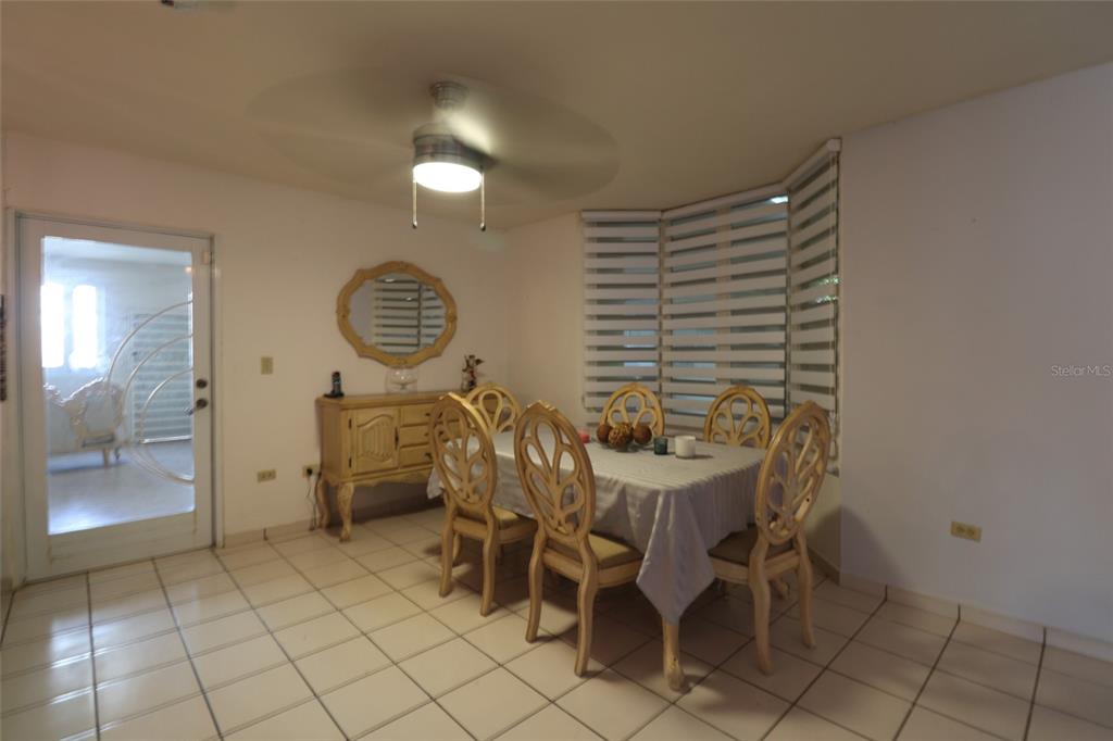 A dining room features a table with six chairs, a sideboard, and tiled flooring — 62 San Luis St. ESTANCIAS DE GRAN VISTA DEV., GURABO, PR