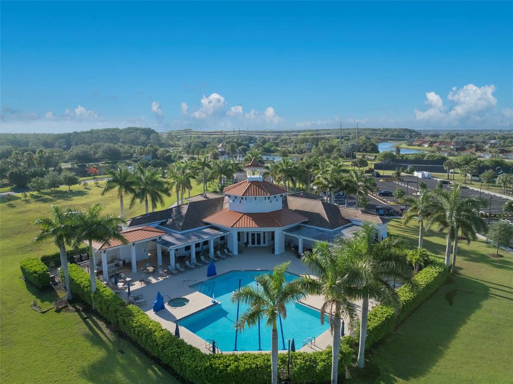 An aerial view shows a community clubhouse with a swimming pool surrounded by palm trees — 2897 APPLE BLOSSOM DRIVE, ALVA, FL