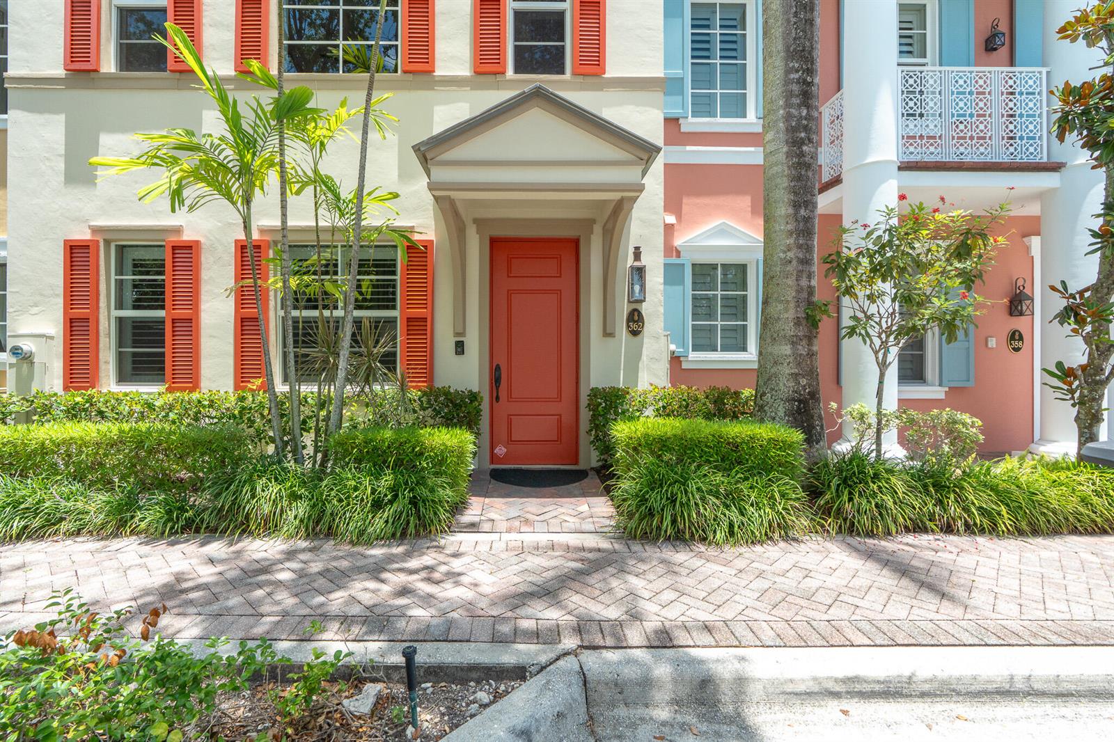 A red front door with a pediment entrance sits between two townhouses with shutters — 362 W Cannery Row Circle, Delray Beach FL 33444, DELRAY BEACH, FL