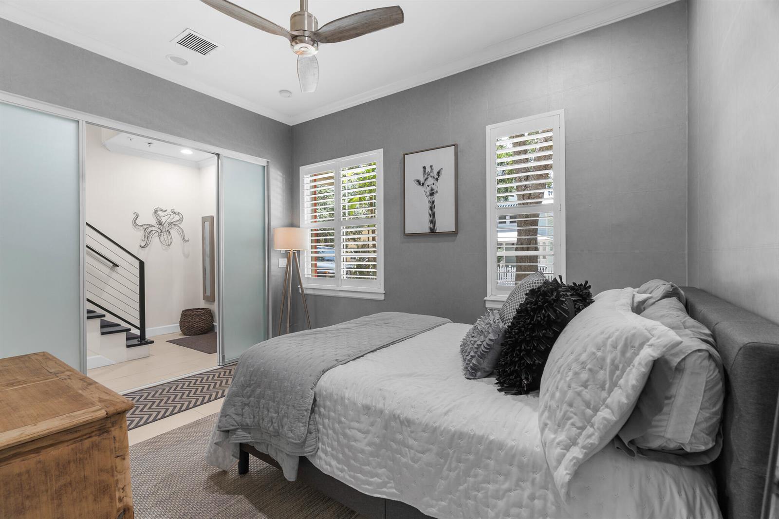 A bedroom with gray walls, a bed, a ceiling fan, and a sliding glass door — 362 W Cannery Row Circle, Delray Beach FL 33444, DELRAY BEACH, FL