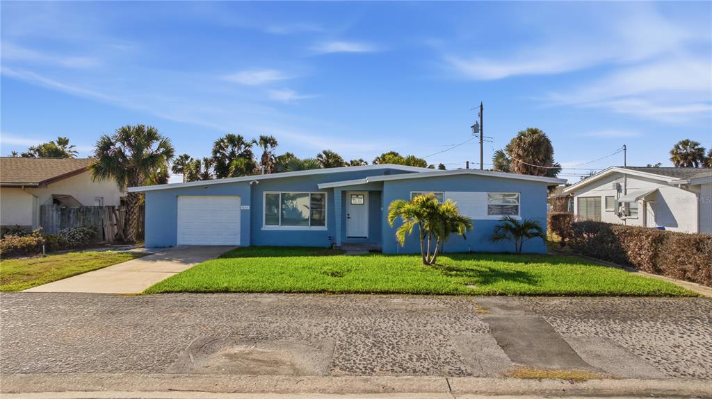 A single-story blue house with a white garage door and a front lawn — 440 89TH AVENUE, ST PETE BEACH, FL