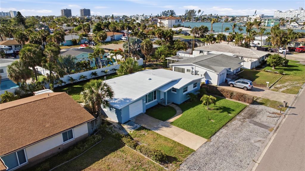 An aerial view shows a blue single-story house with a white roof and attached garage — 440 89TH AVENUE, ST PETE BEACH, FL