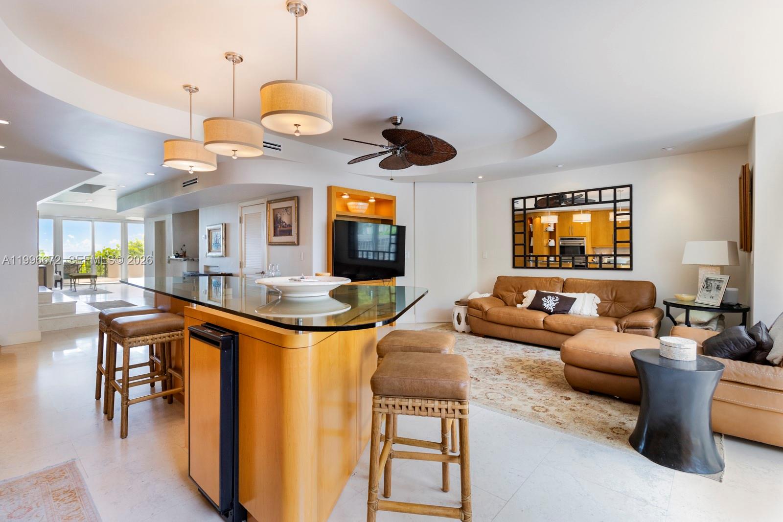 A living room and kitchen area feature a glass-topped island, leather furniture, and recessed lighting — 201 Crandon Blvd # 174, Key Biscayne FL 33149, KEY BISCAYNE, FL