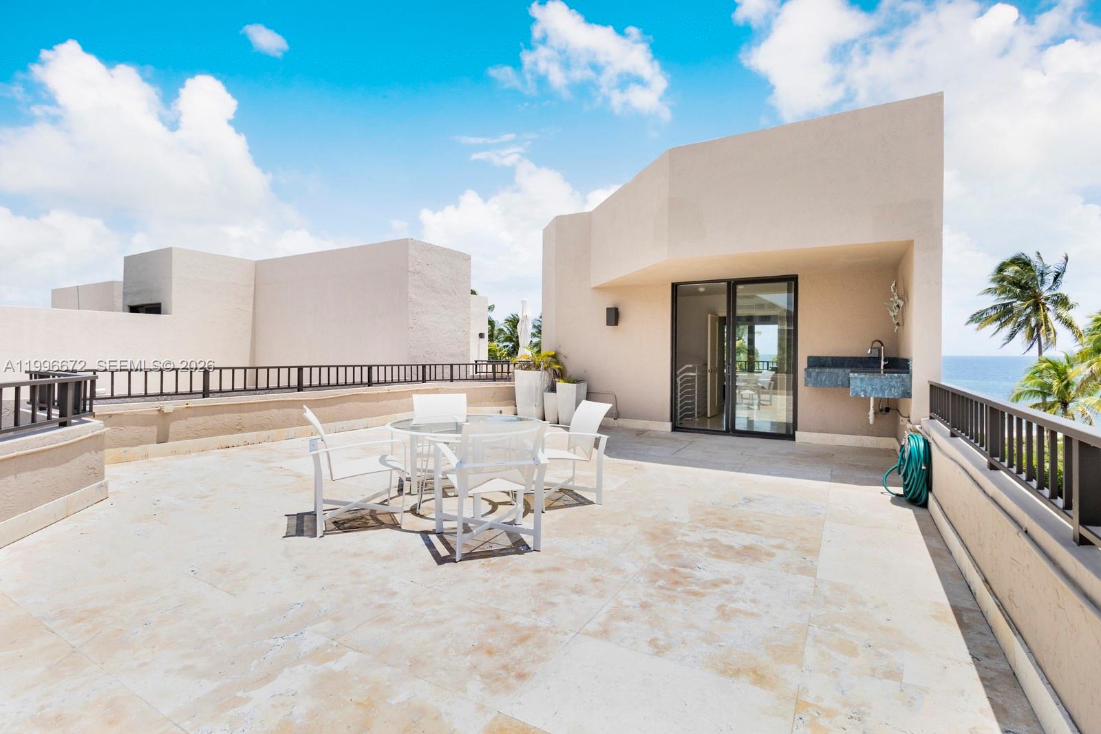 A spacious outdoor terrace features a dining set, a small sink, and ocean views — 201 Crandon Blvd # 174, Key Biscayne FL 33149, KEY BISCAYNE, FL