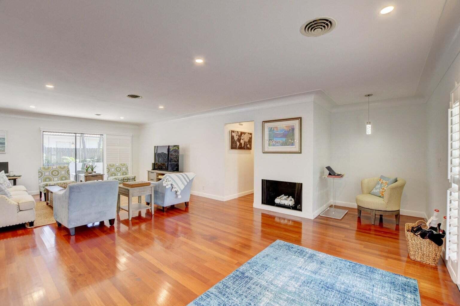 A living room with hardwood floors, a fireplace, and a blue area rug — 2700 Spanish River Road, Boca Raton FL 33432, BOCA RATON, FL