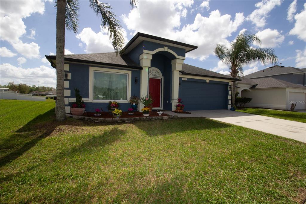 A blue single-story house with a red front door and a two-car garage — 25500 GEDDY DRIVE, LAND O LAKES, FL
