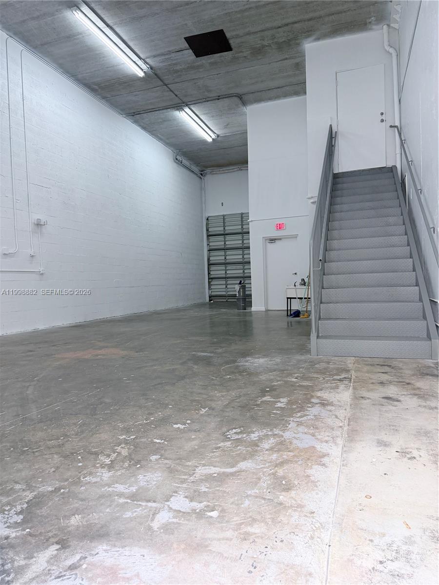 This industrial warehouse space features a concrete floor, high ceilings, and a metal staircase — 13210 SW 132 Ave Unit 1C, Miami FL 33186, MIAMI, FL