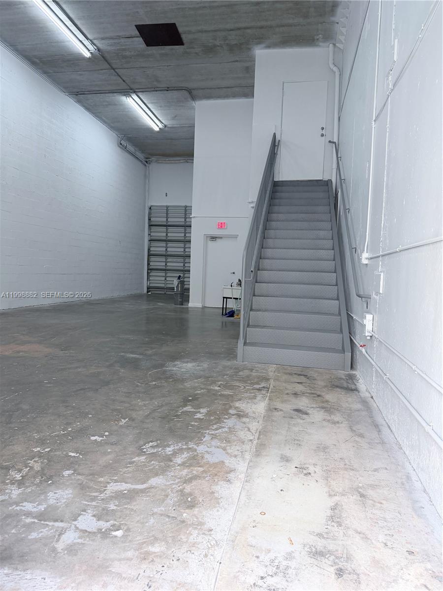 This industrial warehouse space features a concrete floor, high ceilings, and a metal staircase — 13210 SW 132 Ave Unit 1C, Miami FL 33186, MIAMI, FL