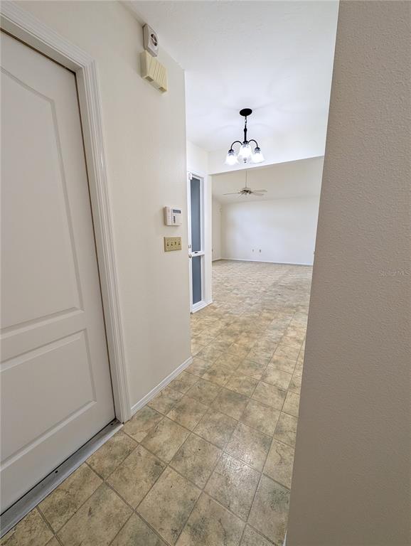 A tiled hallway leads to an open living area featuring a chandelier and ceiling fan — 1315 8TH STREET W, PALMETTO, FL