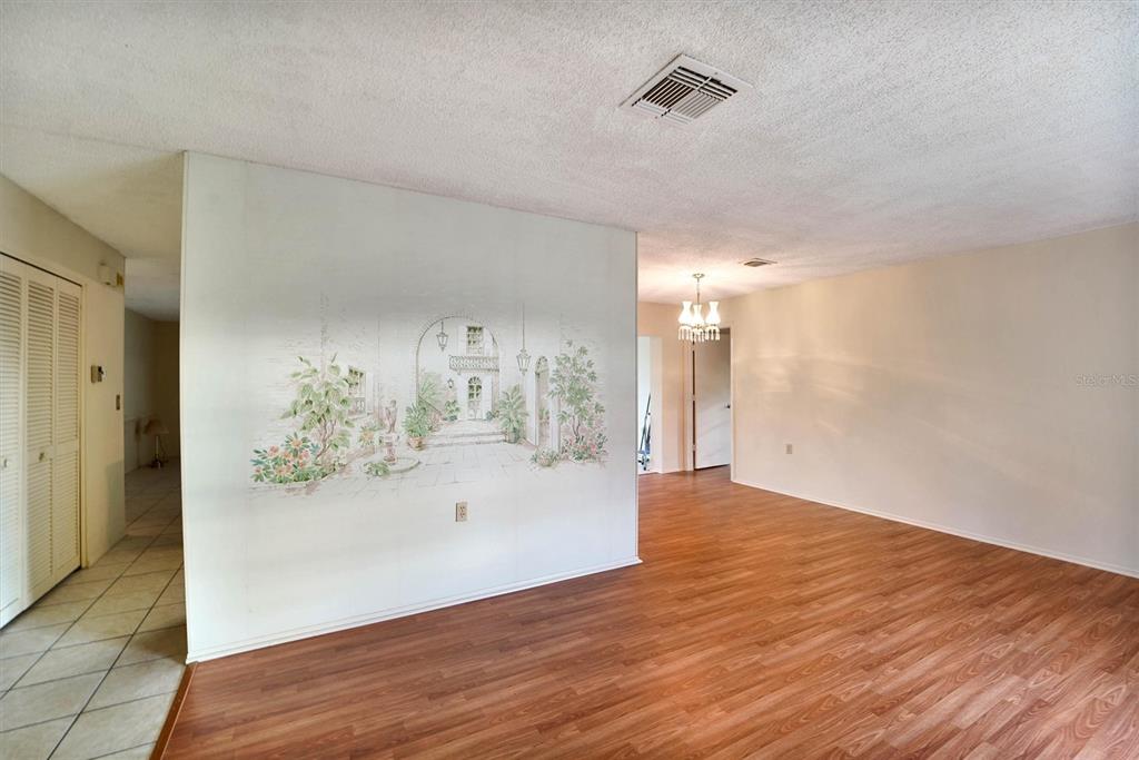 A room with wood-look flooring, a mural on a partition wall, and a ceiling vent — 10550 CALICO LOOP, PORT RICHEY, FL